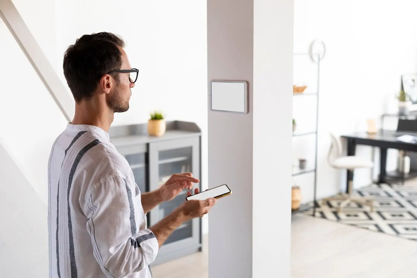 A man uses a smartphone in his automated home.